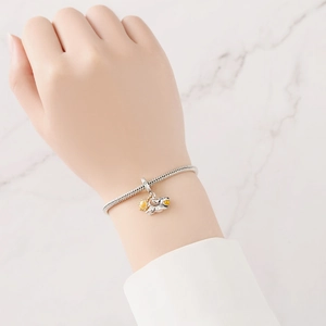 Pulsera de cadena de serpiente plateada con dijes de perro y sol amarillo en la muñeca
