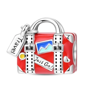 Detailed view of red enamel suitcase charm featuring 'Travel' tag and 'Just Go' lettering