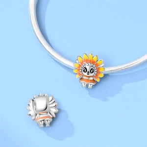 Detail showing cartoon sunflower girl charm with orange enamel on a silver bracelet