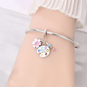 Silver charm bracelet featuring artistic palette and pink enamel flower on wrist