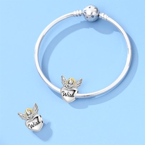 Detailed view of silver charm bracelet with angel heart pendants and Wish engraving