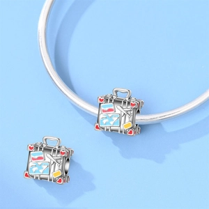 Detailed view of silver suitcase charm with colorful map enamel and 3D airplane relief