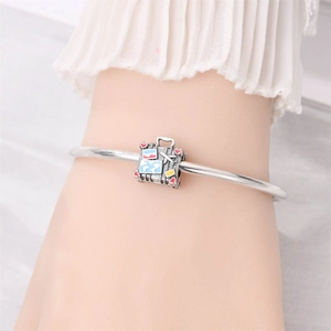 Detailed view of silver globe suitcase charm with enamel world map on a beaded bracelet