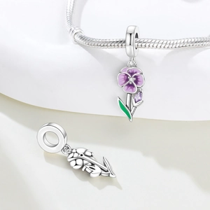 Detail of silver iris charm pendant with purple enamel petals and sparkling zircons