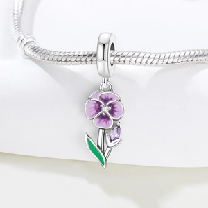 Macro shot of purple pansy flower charm with enamel petals and zircon on a silver bracelet