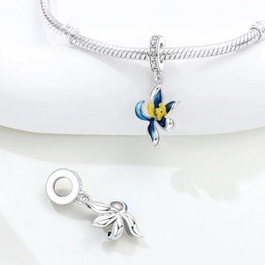 Macro detail of blue gradient enamel flower charm with zircon inlays on a silver bracelet