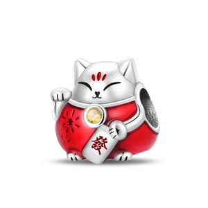 Dettaglio macro dello charm gatto della fortuna in argento con smalto rosso e zircone