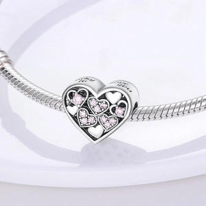 Macro shot of silver heart charm with pink zircons and Lucky to have you engraving