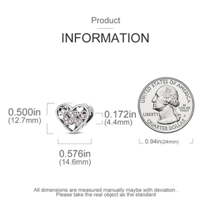 Detailed view of heart-shaped silver charm with pink cubic zirconia next to a coin