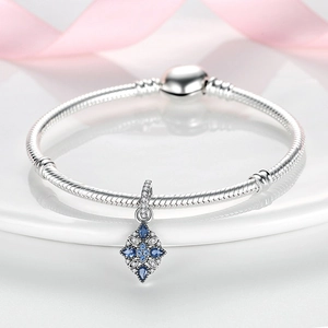 Detaillierte Makroansicht des silbernen Schlangenarmbands mit blauem Edelsteinanhänger