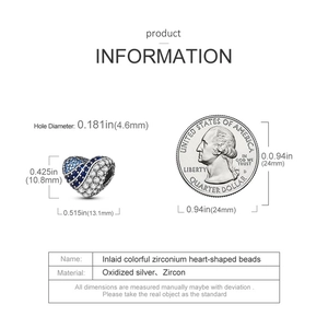 Macro shot of silver heart charm with blue and white zircons next to a coin for scale