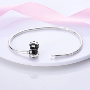 Dettaglio bracciale maglia snake in argento con chiusura a corona aperta su seta rosa