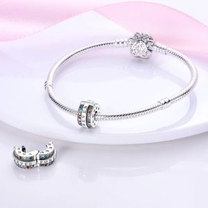 Macro view of silver charm bead with rainbow zircons and FOREVER engraving on snake bracelet