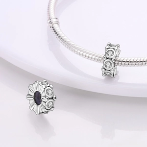 Makroansicht silberner Strahlenblüten-Charms an einem Schlangenkettenarmband