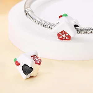 Makroaufnahme von Weihnachts-Hausanhänger mit Emaille-Schneeflocken auf Schlangenkette