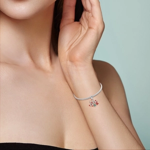 Primer plano de pulsera de plata con dijes de Papá Noel y árbol de Navidad