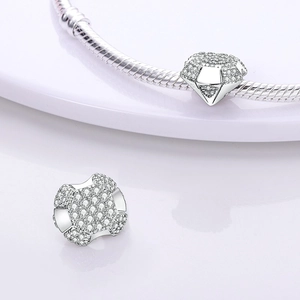 Macro detail of silver diamond-shaped charm with pavé cubic zirconia on snake chain