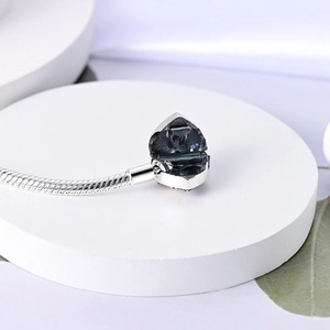 Vista macro della clip a cuore argentata sul bracciale a maglia snake con dettagli
