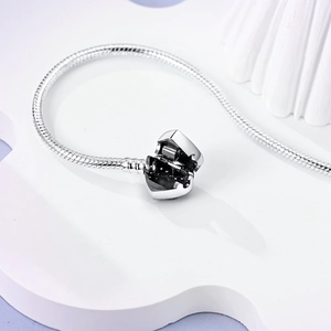 Detailed macro view of the open heart clasp on a silver snake chain bracelet