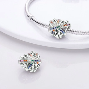 Close-up of silver hollow heart charms with colorful stones on a snake chain