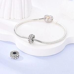Macro shot of silver heart clasp with rose gold paw print and colorful flower charms