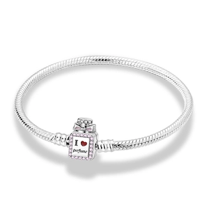 Detail of silver snake chain bracelet featuring a perfume bottle charm with pink bow detail