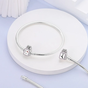 Detailed shot of silver snake chain bracelet with pink crystal perfume bottle charms