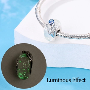 Luminous white feather glass charm on silver snake chain bracelet with green glow effect