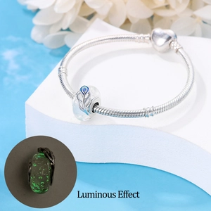 Luminous feather charm on silver snake chain bracelet with heart clasp and glowing effect