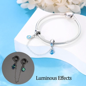 Leuchtende Hamsa und Evil Eye Anhänger an silbernem Sicherheitsketten-Armband-Detail