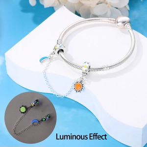 Vista detallada de dijes luminosos de sol y luna en una pulsera de cadena de plata