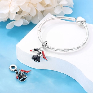 Detail of silver snake chain bracelet with red high heel, lipstick and dress charms