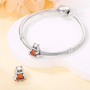 Detailed close-up of a silver cat charm with orange heart gemstone on snake chain