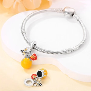 Detail of silver snake chain bracelet with bee and maple leaf charms and enamel beads