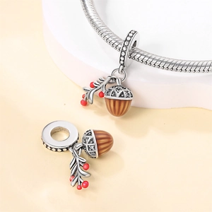 Silver acorn charm with white zircon crystals and red berry leaf on snake chain bracelet