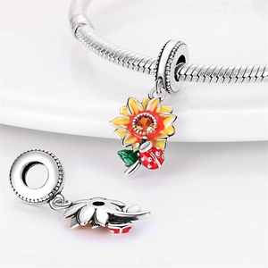 Macro view of S925 sunflower and ladybug charm with vibrant enamel and orange gemstone