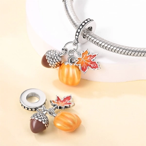 Detailed charm set with maple leaf, pumpkin and acorn on silver snake chain bracelet