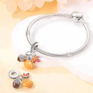 Detail of silver snake chain bracelet featuring autumn charms like pumpkin and maple leaf