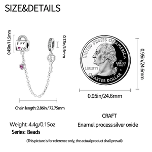 Detail of silver heart lock charm with pink enamel and size comparison using a coin