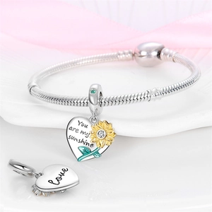 Close-up of heart sunflower charms with You are my sunshine engraving on silver bracelet