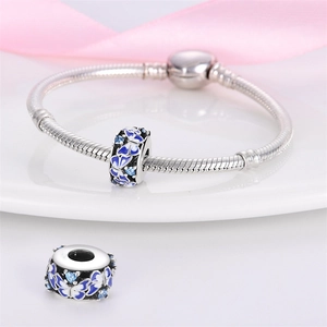 Gros plan d'un charme papillon en émail bleu avec zircons sur un bracelet argenté
