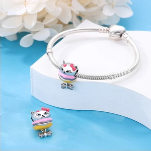 Macro detail of silver snake chain bracelet with cat macaron charms and zircon bow