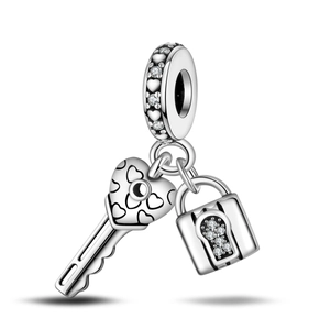 Detailed view of silver heart lock and key charm with sparkling crystal pavé setting