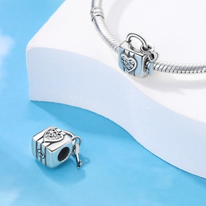 Macro detail of silver heart lock charm with white stones on snake chain