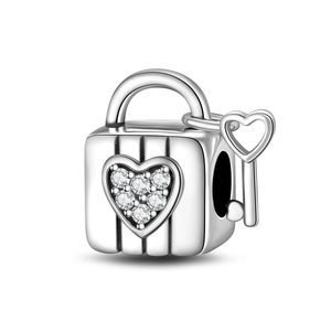 Macro shot of silver heart lock charm with inlaid crystals and matching key detail