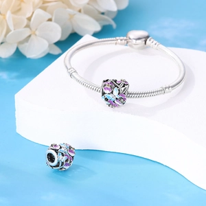 Détail macro des breloques papillon et fleurs avec émail violet et oxydes de zirconium