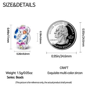 Vue détaillée de la taille du charm fleur papillon en argent à côté d'une pièce