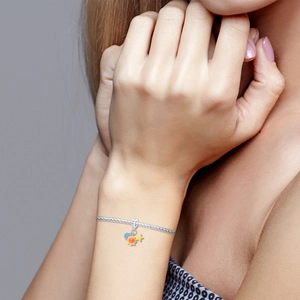 Détail du bracelet en argent avec breloques émaillées en forme de soleil lune et étoile