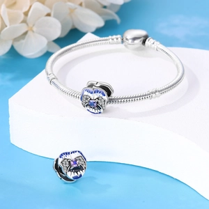 Détail du bracelet maille serpent avec breloque pensée bleue et zircon violet brillant
