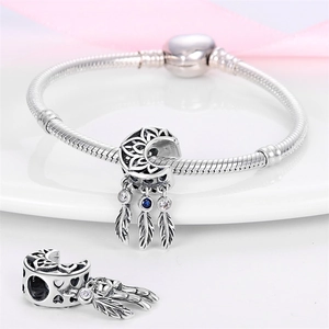 Silver moon dreamcatcher charm bracelet with blue zircon feathers on white ceramic